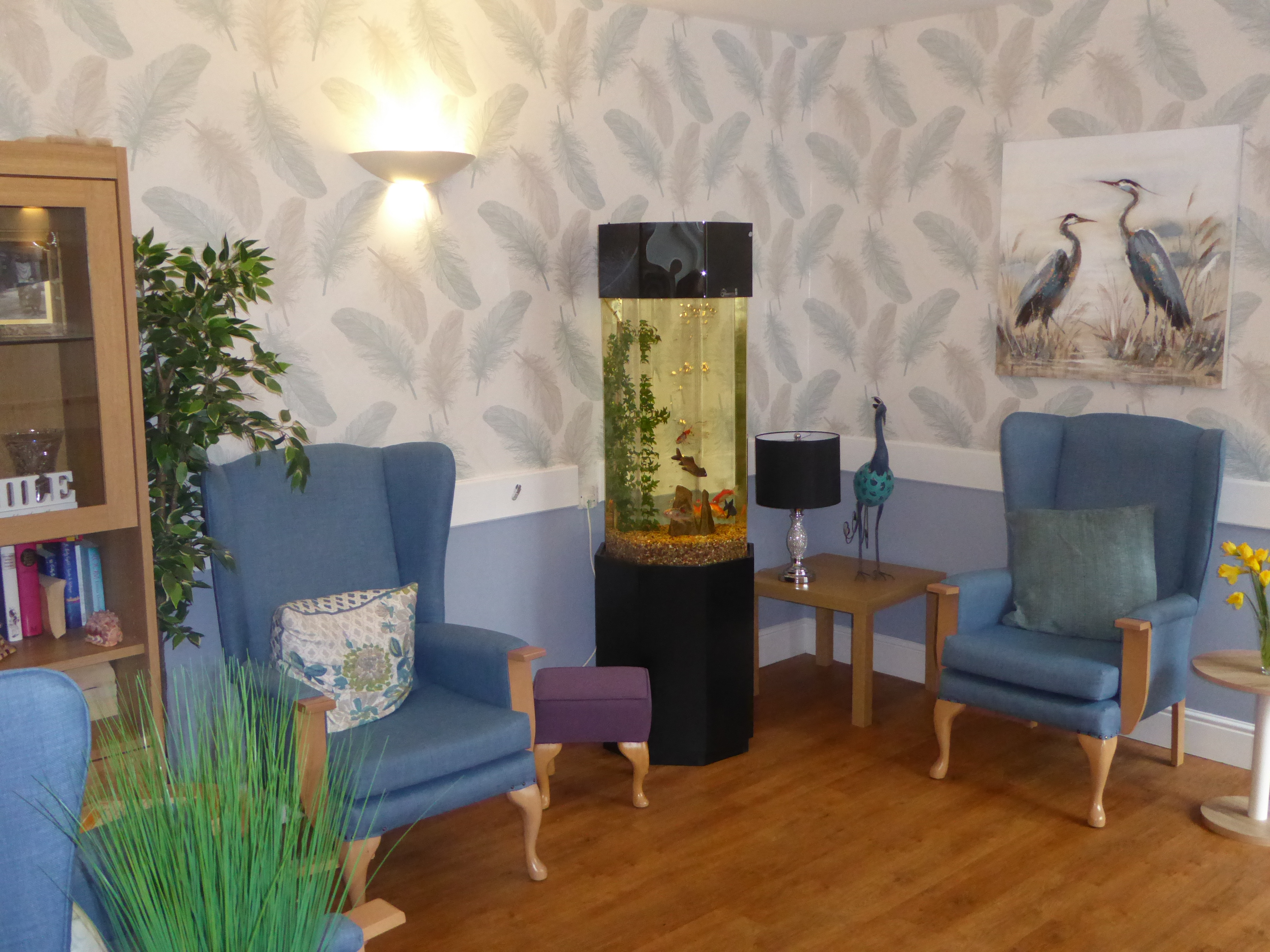 Lounge area with blue chairs and a fish tank