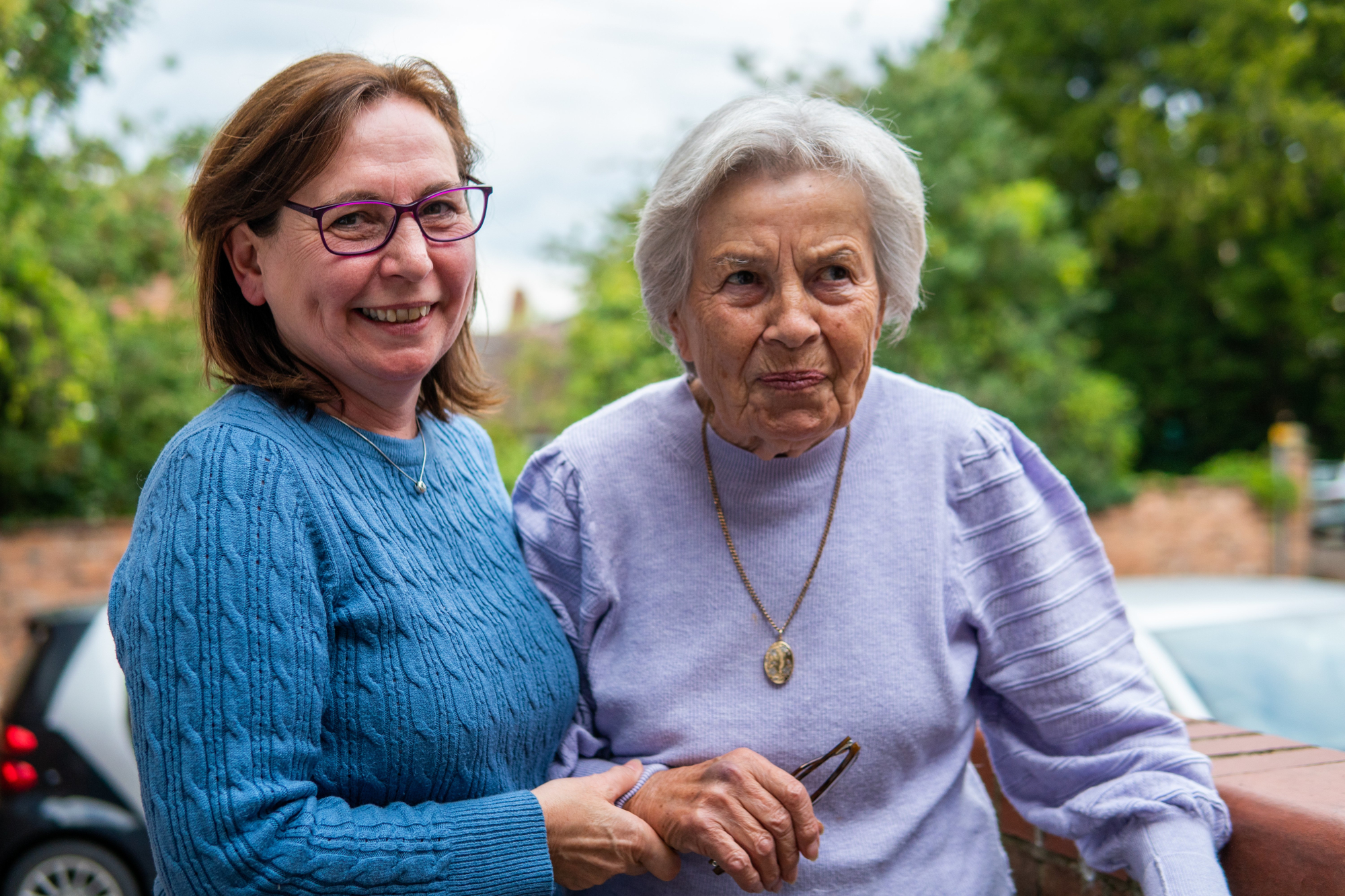 Older Woman Being Supported By Woman Whilst Walking