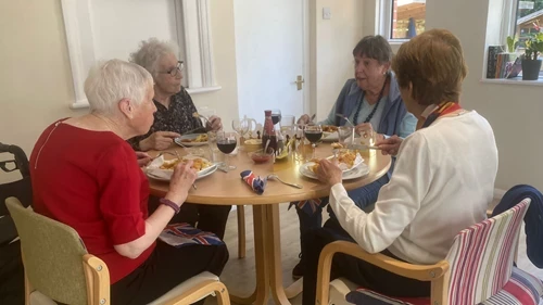 A group of women sitting at a table eating fish and chips