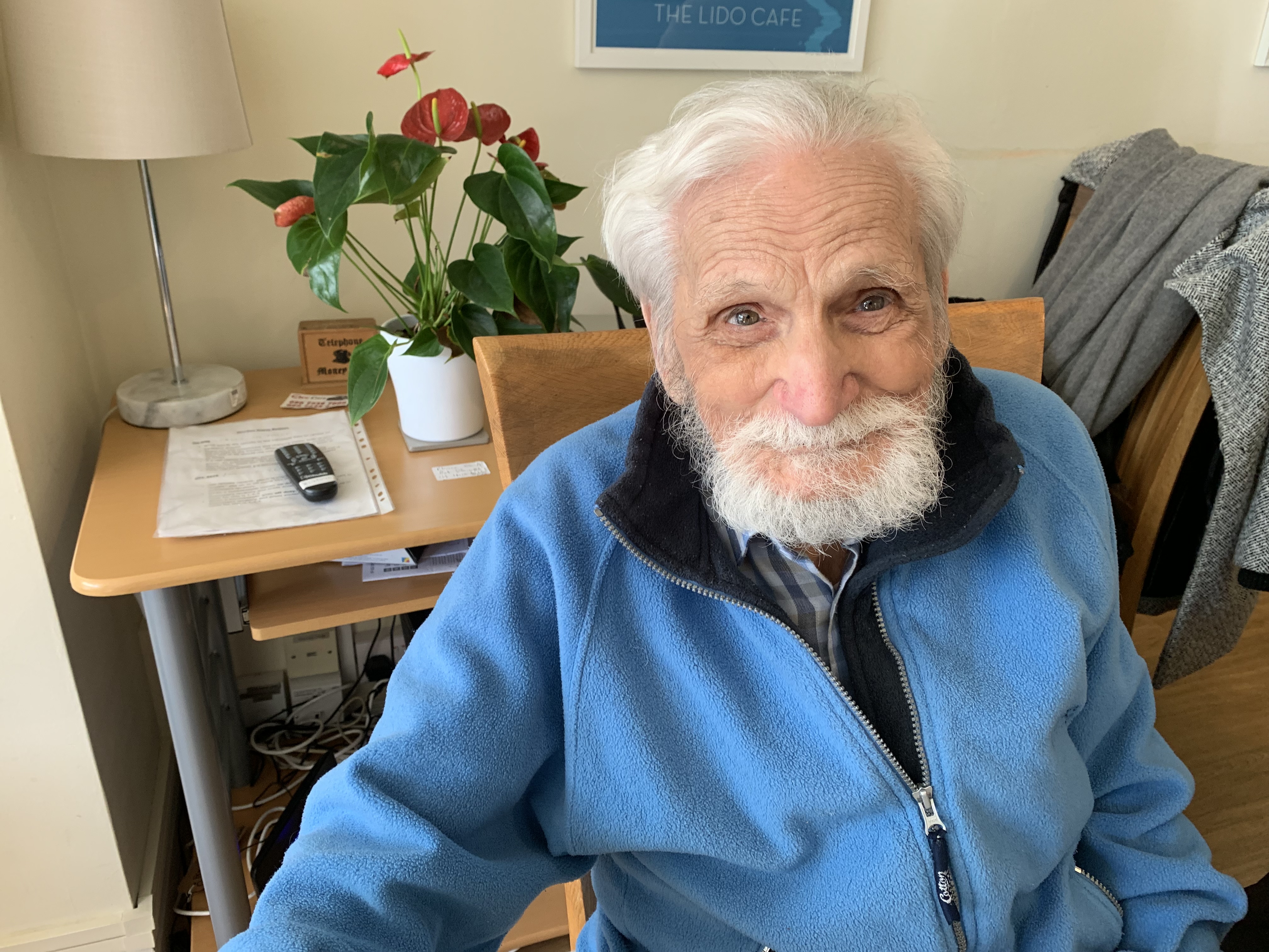 Smiling resident sitting in Abbeyfield House, Dulwich