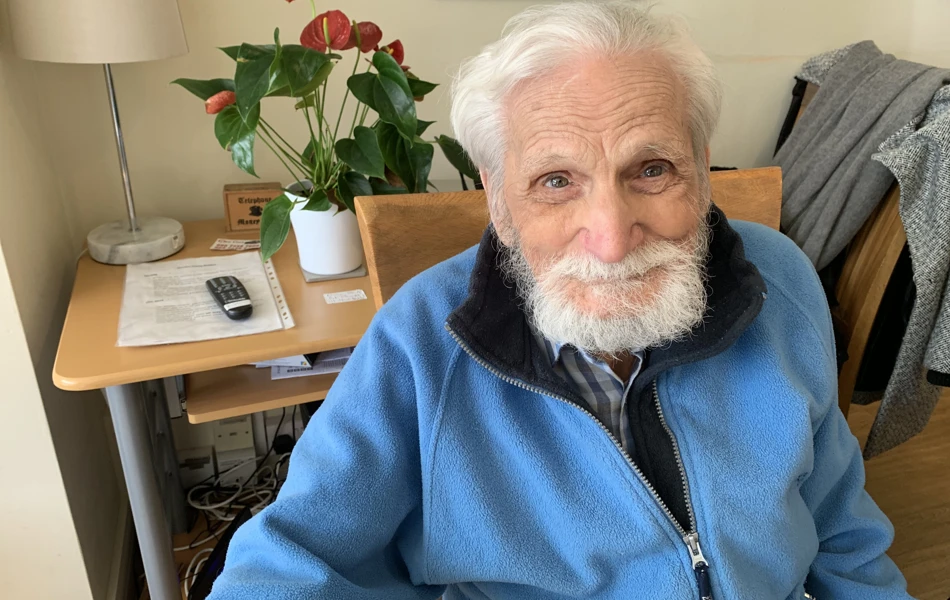 Smiling resident sitting in Abbeyfield House, Dulwich