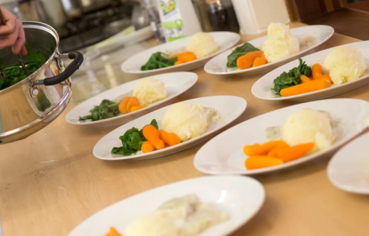 The house chef is plating up dinner for the residents