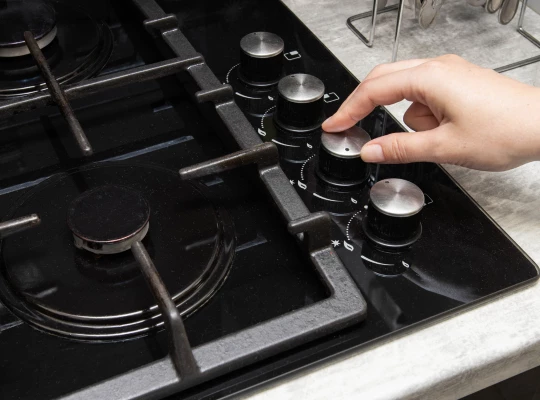 Person Adjusting Temperature On Cooker