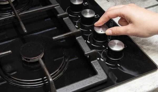 Person Adjusting Temperature On Cooker