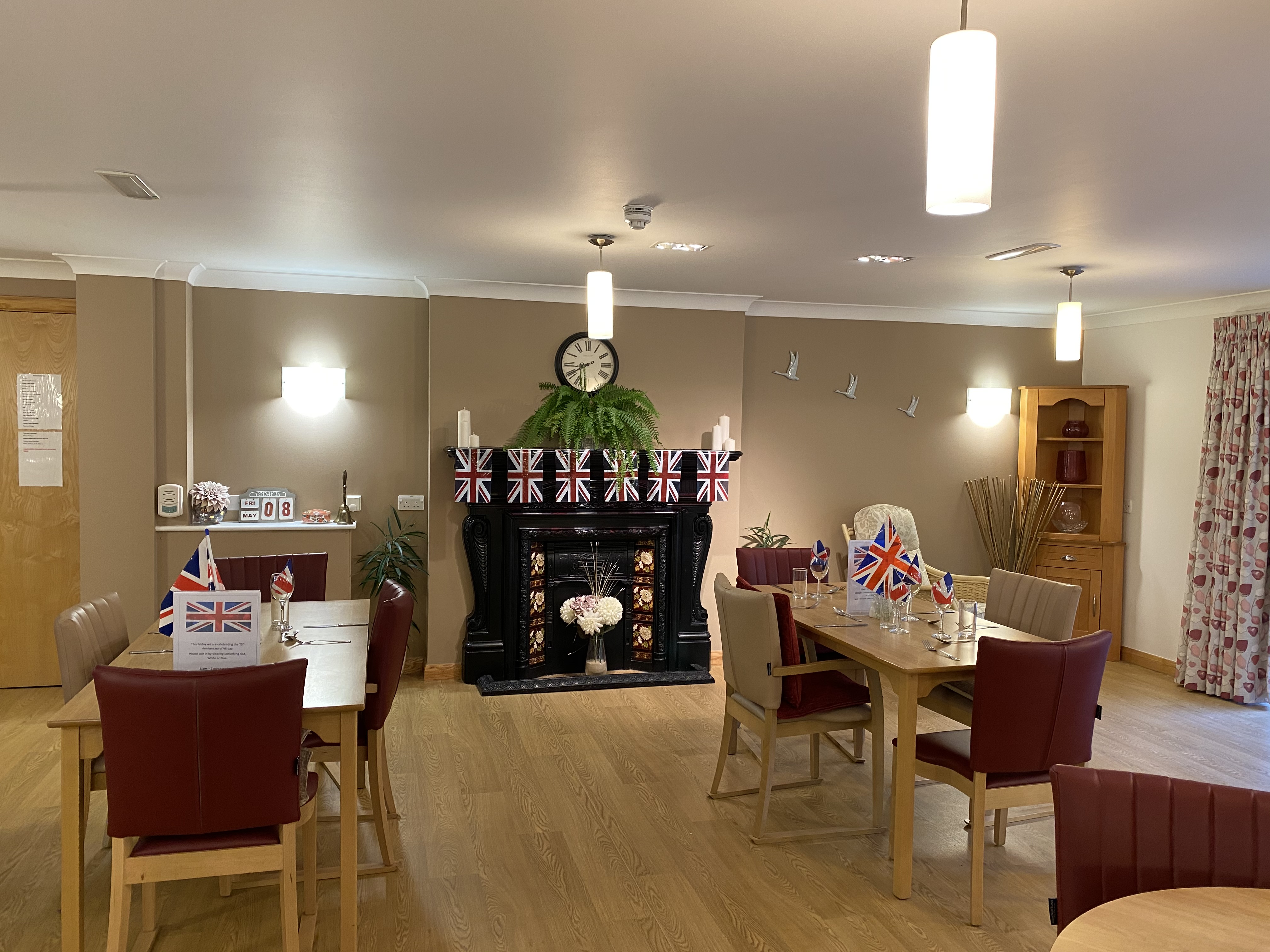 Dining room with union jack bunting tables and chairs for residents at Westbourne House
