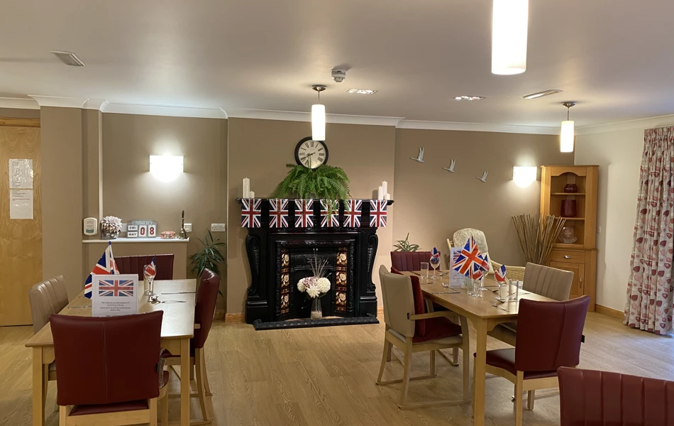 Dining room with union jack bunting tables and chairs for residents at Westbourne House