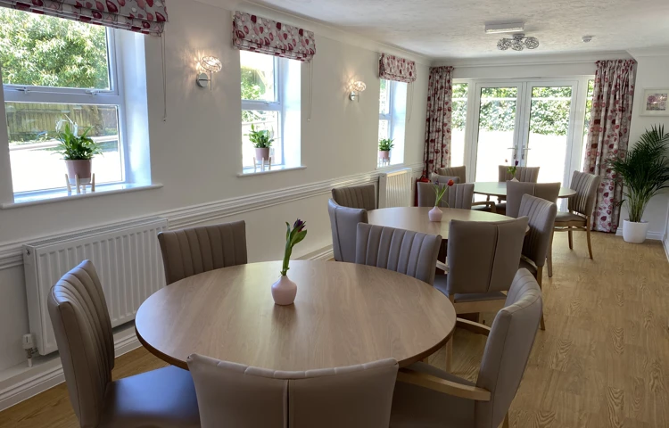 A bright modern dining area with ample seating for residents