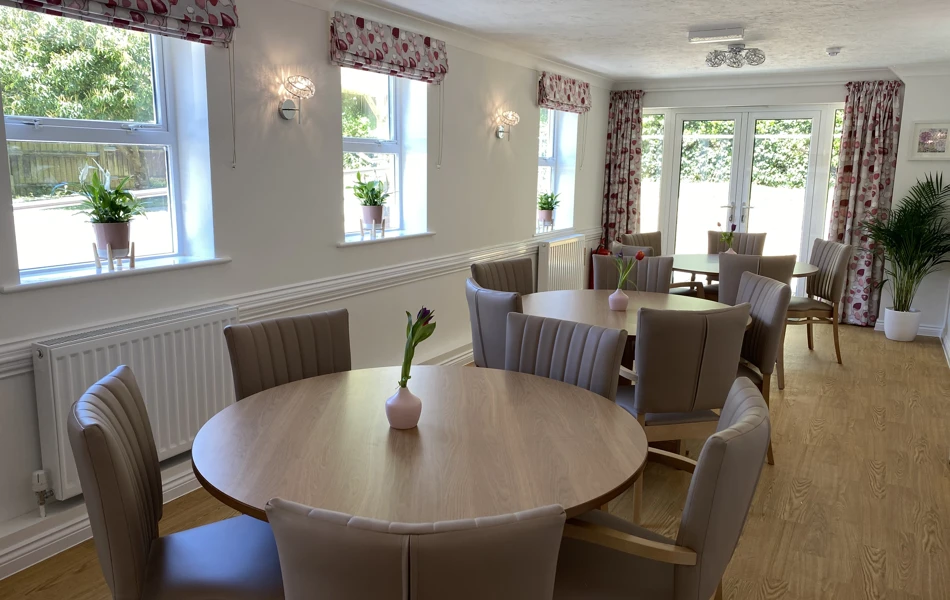 A bright modern dining area with ample seating for residents