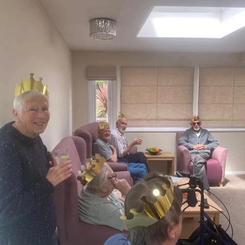 A group of people sitting down with gold crowns on