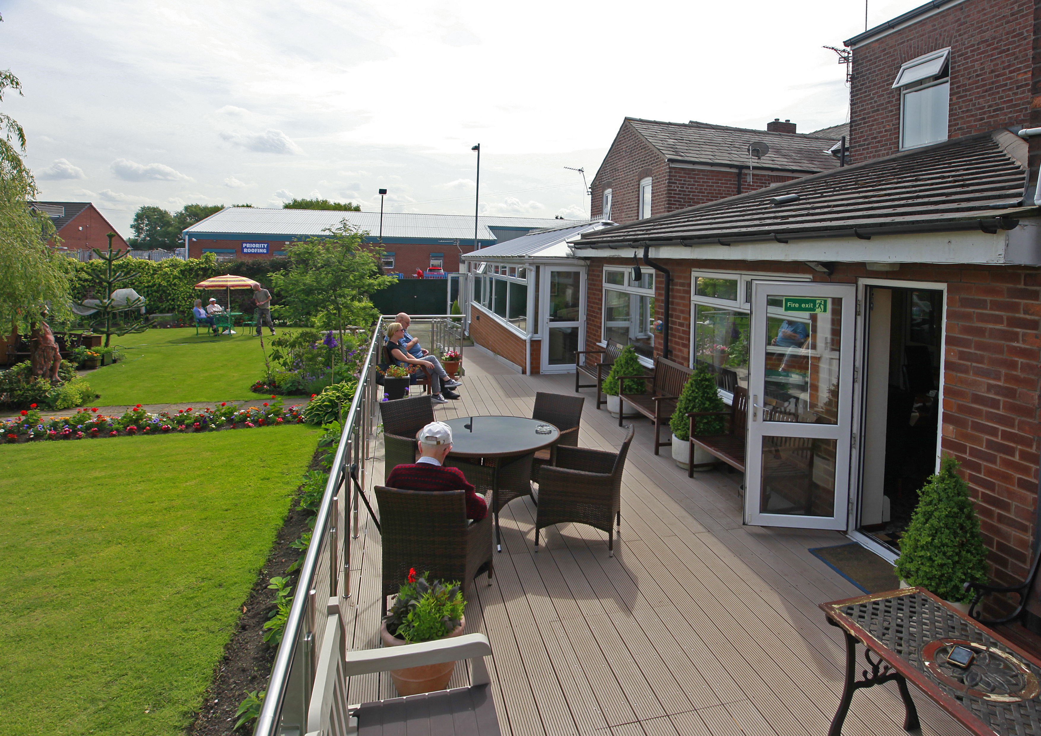 Residents are sat outside on the decked area in the sun