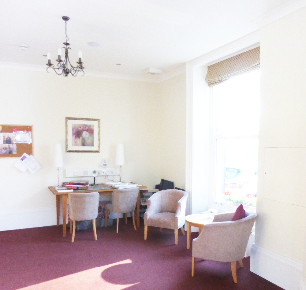 A seating area and desk with a pink carpet in a white room at Ing Royde,