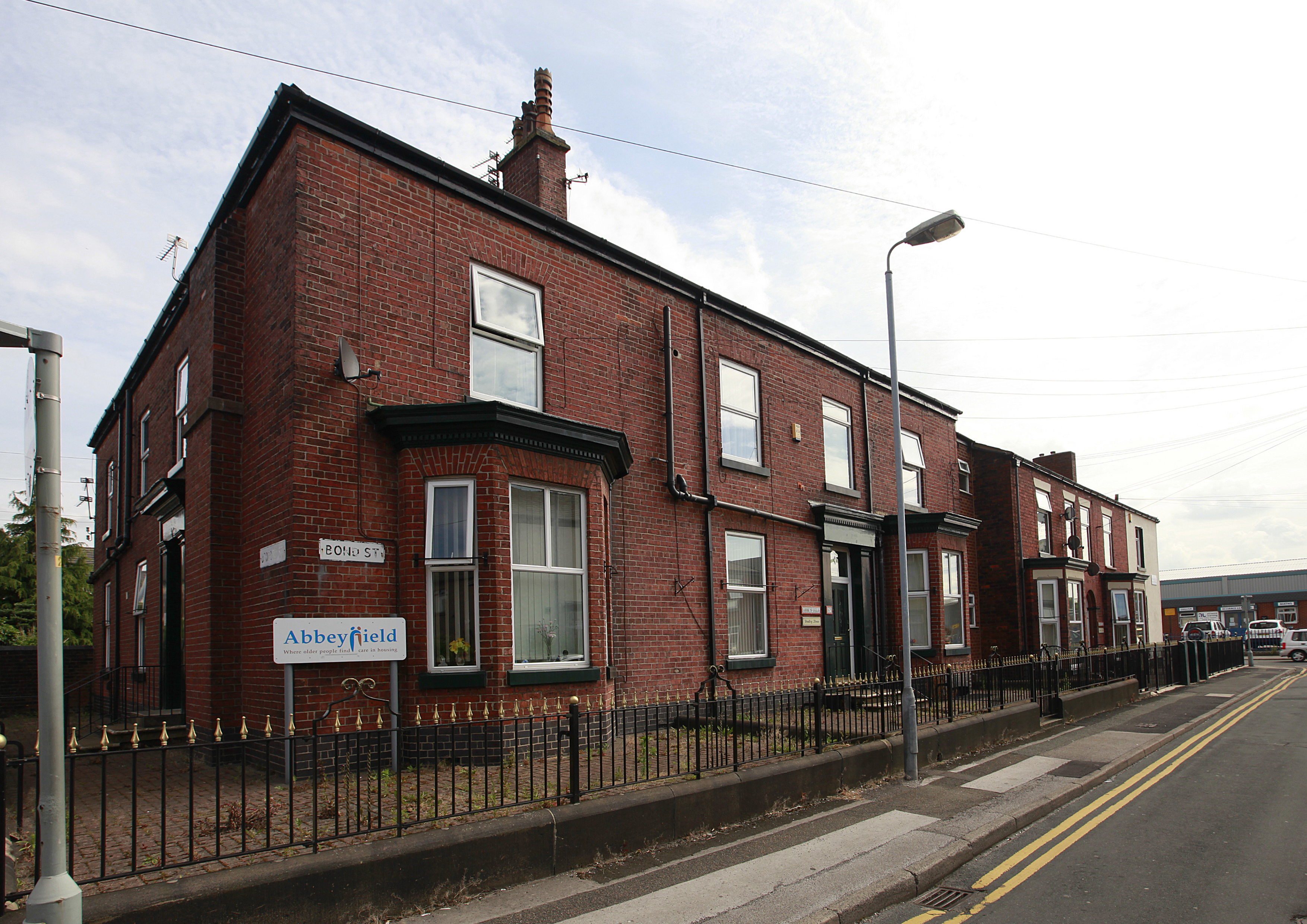 The front of the house with an Abbeyfield sign on the corner