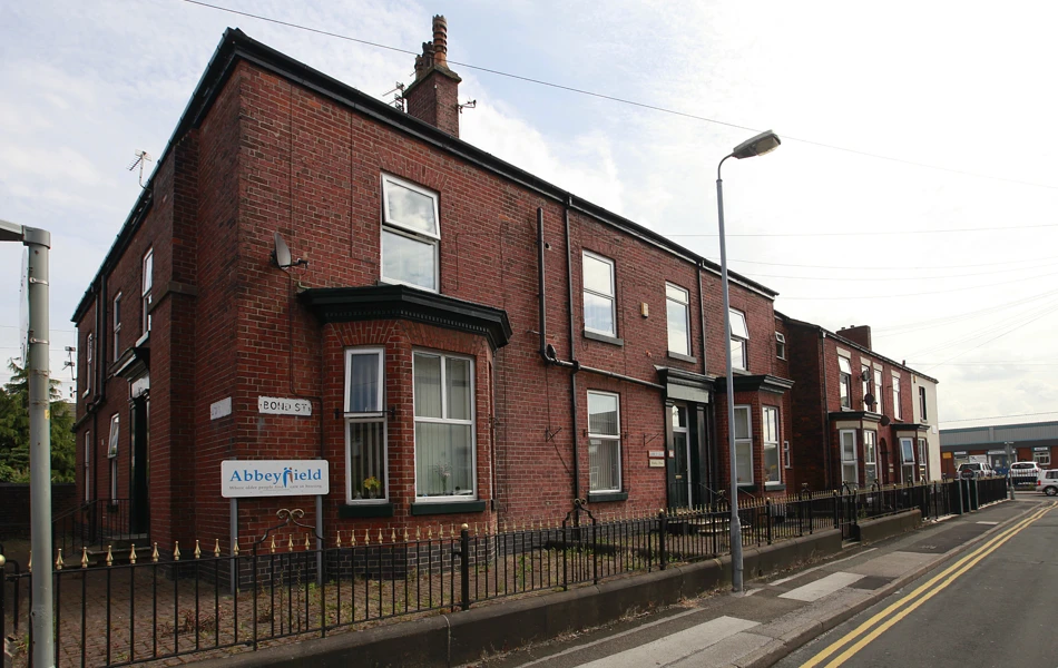 The front of the house with an Abbeyfield sign on the corner