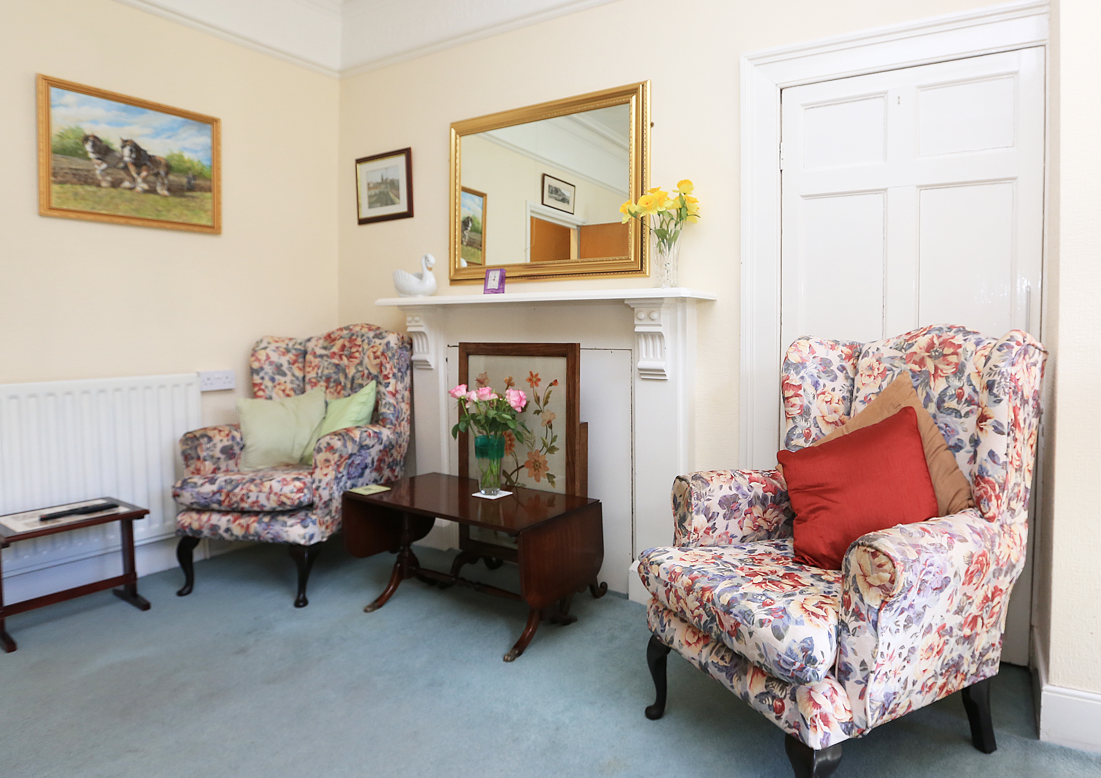 Chairs set to the side of a fireplace in the lounge