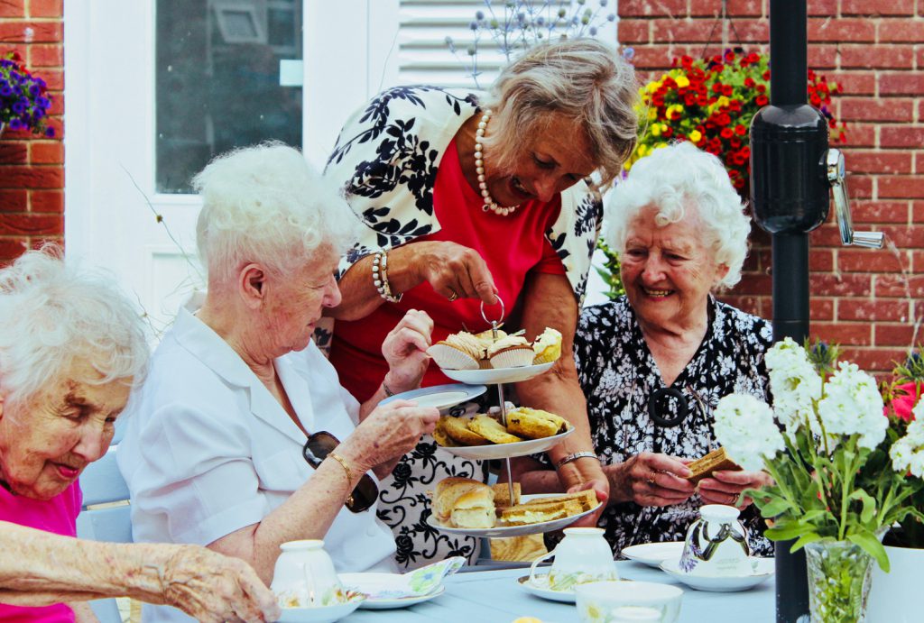 Residents are sat enjoying afternoon tea outside