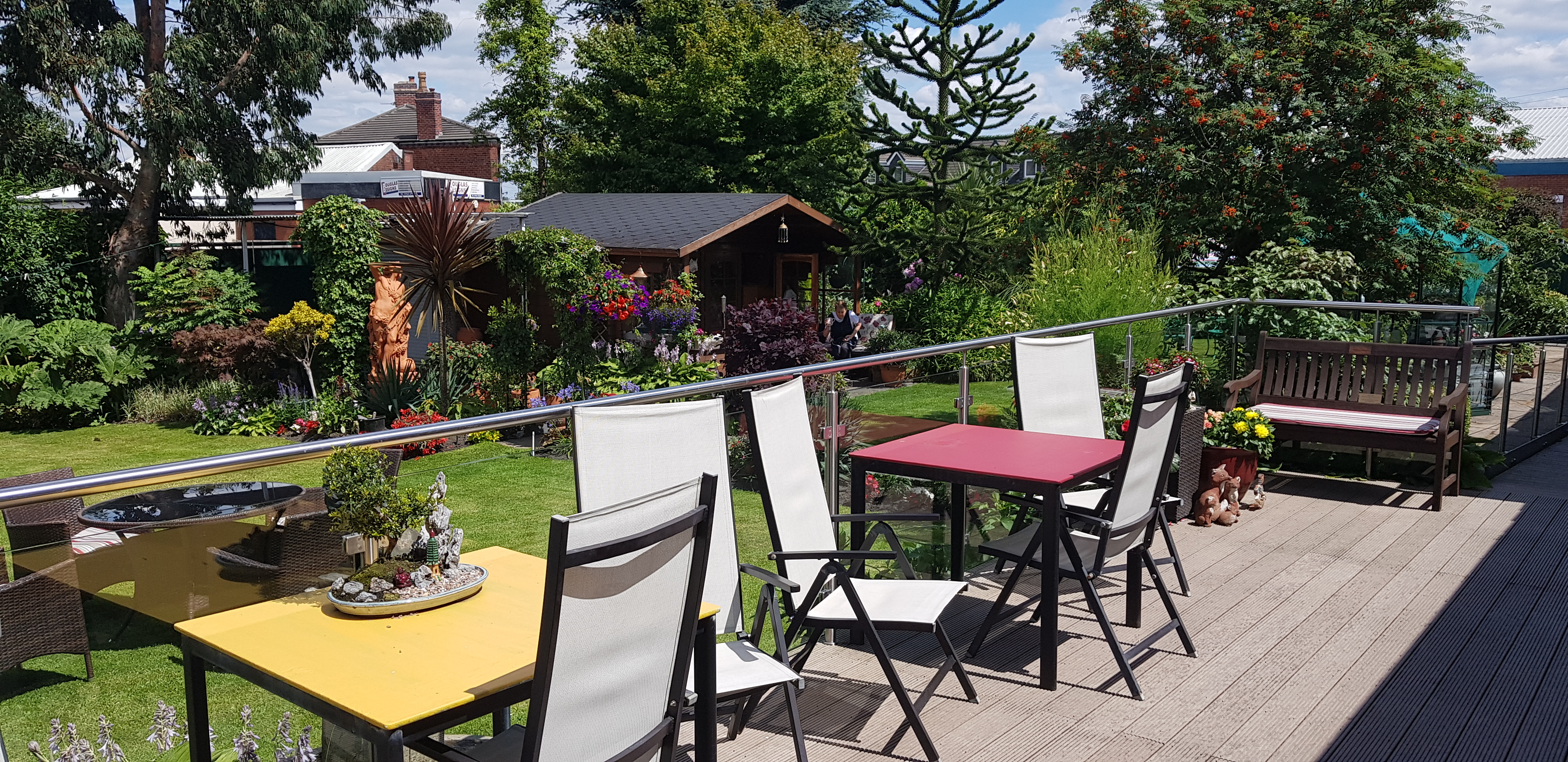 Tables and chairs outside with a glass balcony around them