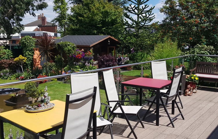 Tables and chairs outside with a glass balcony around them