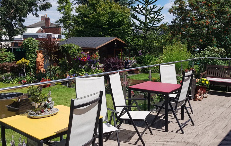 Tables and chairs outside with a glass balcony around them