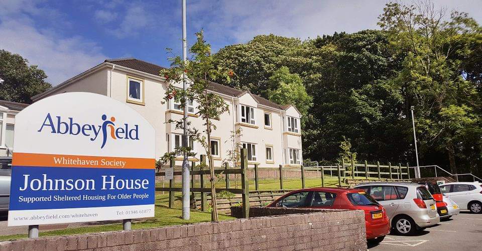 A large white house with a sign to the front