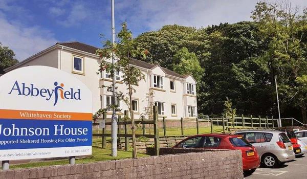 A large white house with a sign to the front