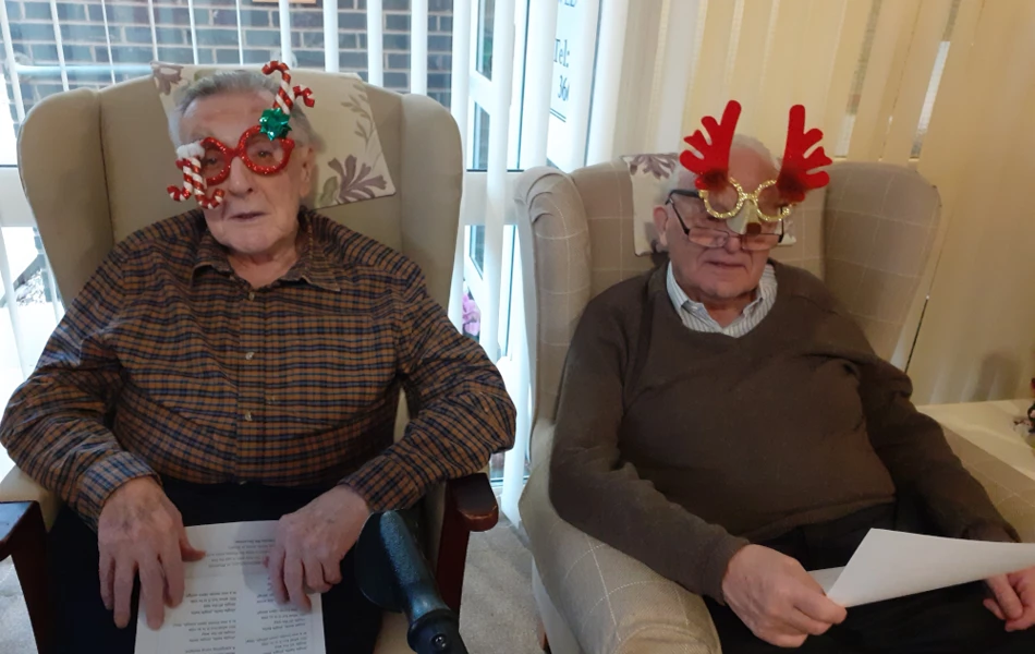 Residents Dressed In Festive Glasses Sitting Together