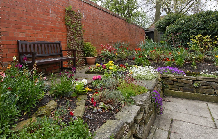 Raised beds in the garden with a bench in the garden at Earl Keelan House DL3 8PD