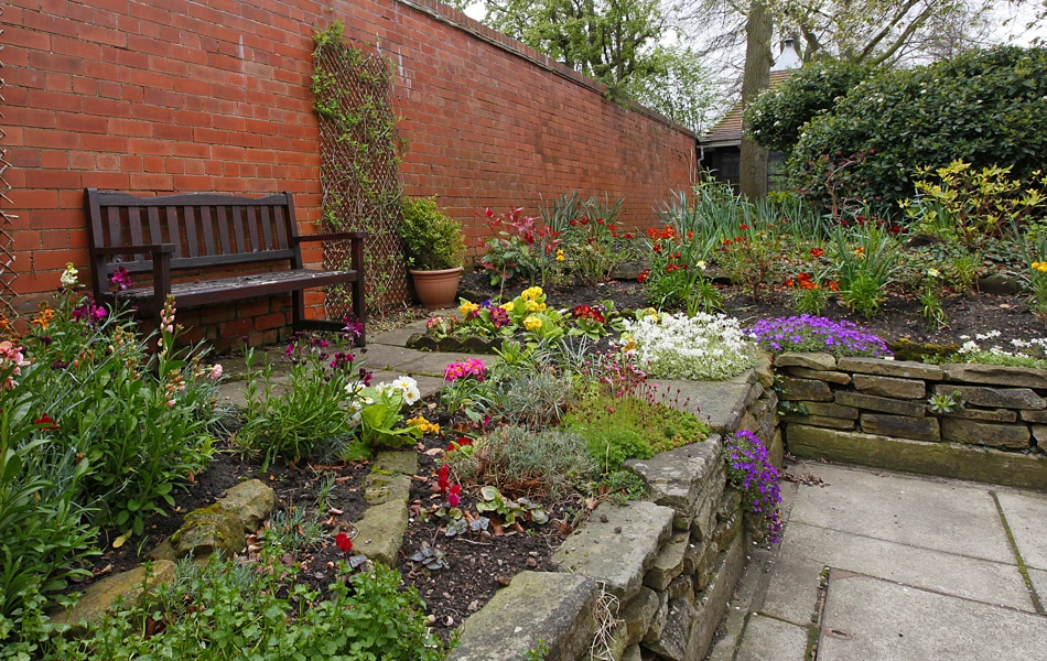 Raised beds in the garden with a bench in the garden at Earl Keelan House DL3 8PD