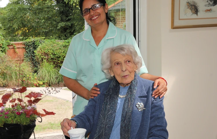 Member of staff smiling with resident at Maitland House