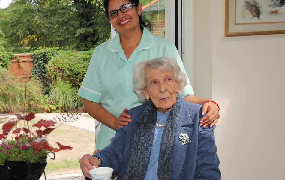 Member of staff smiling with resident at Maitland House