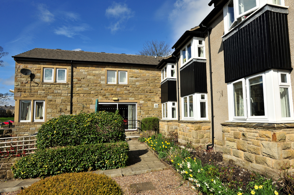 The path leading around the gardens with flowers and shrubs at Abbeyfield, Settle