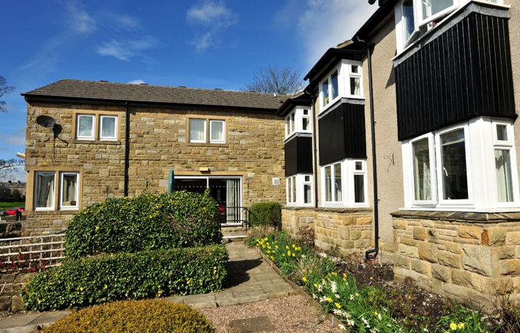 The path leading around the gardens with flowers and shrubs at Abbeyfield, Settle