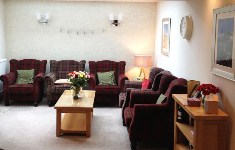 Lounge area with armchairs and flower arrangements on the tables
