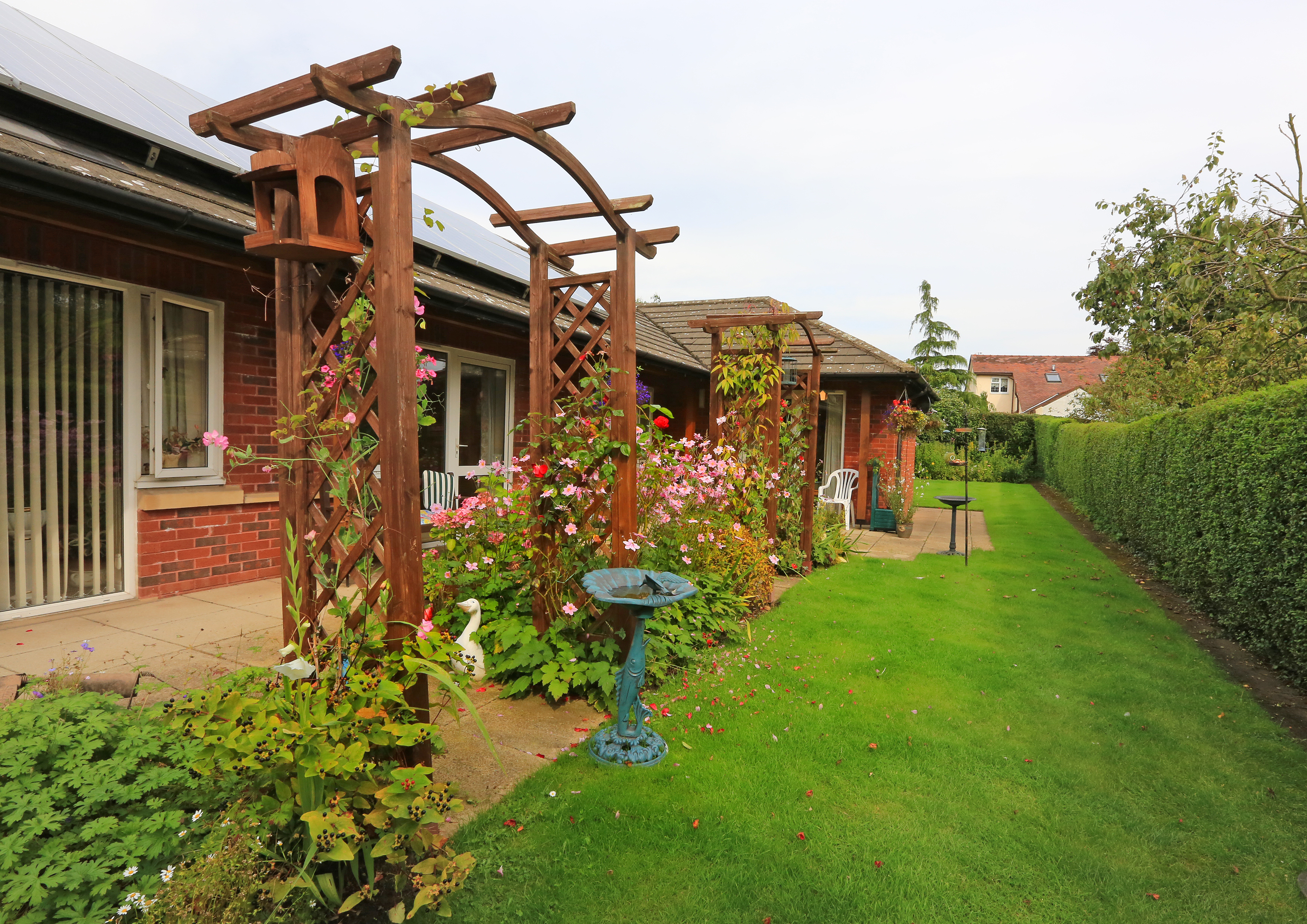 A bright garden with ornaments and a bird bath
