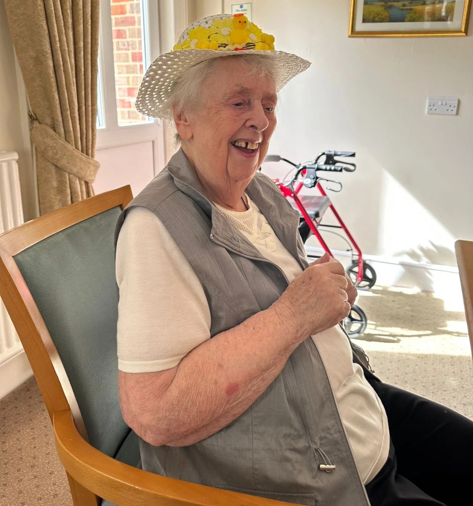 An older lady smiling wearing an easter bonnet