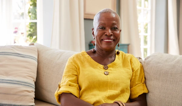 Smiling Older Woman Sitting On Sofa