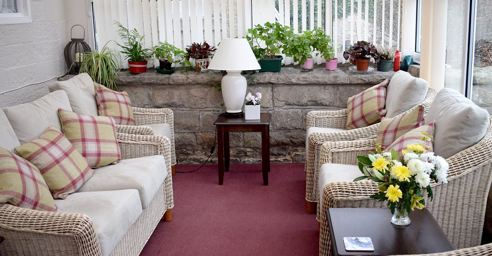 The conservatory area with a sofa and chairs