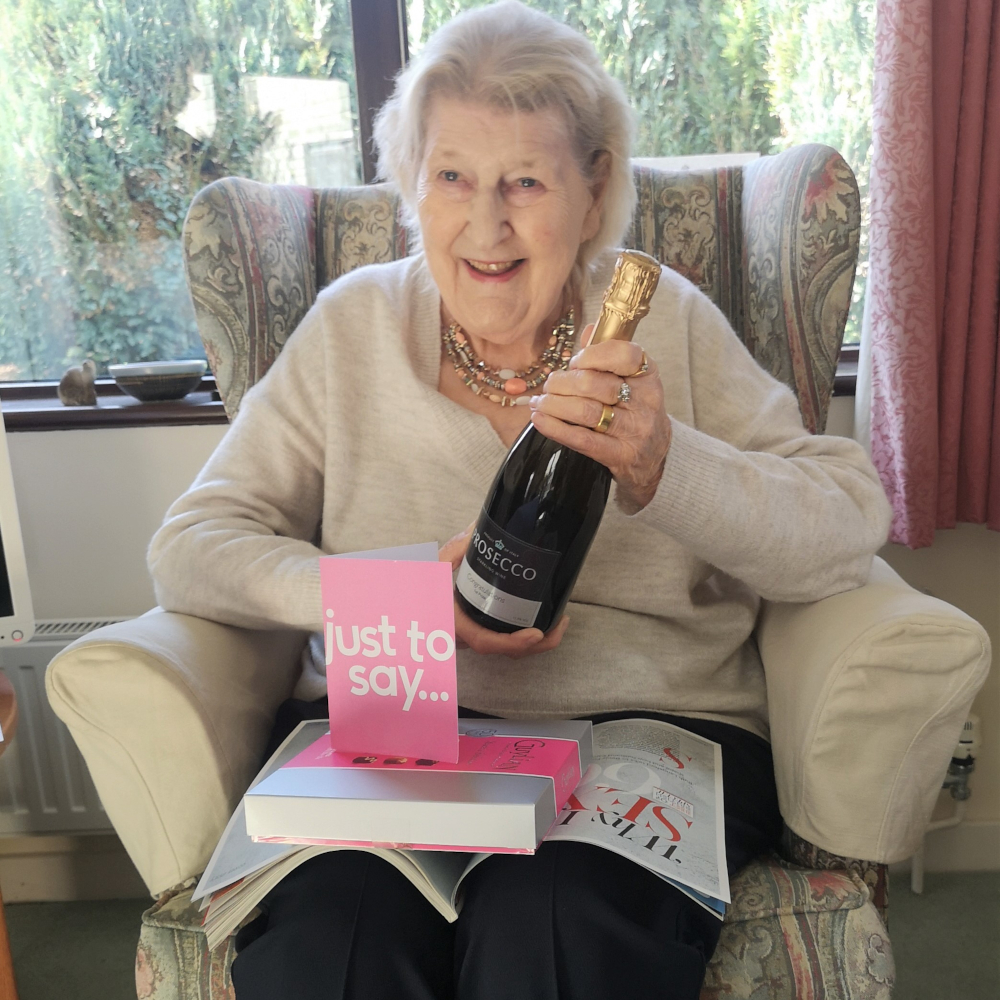 resident-holding-a-bottle-of-champagne-after-winning-competition at Abbeyfield House, Chipping Sodbury BS37 6LB