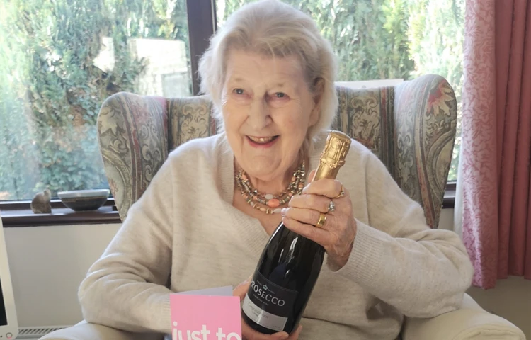 resident-holding-a-bottle-of-champagne-after-winning-competition at Abbeyfield House, Chipping Sodbury BS37 6LB