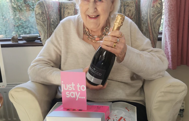 resident-holding-a-bottle-of-champagne-after-winning-competition at Abbeyfield House, Chipping Sodbury BS37 6LB