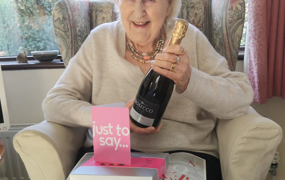 resident-holding-a-bottle-of-champagne-after-winning-competition at Abbeyfield House, Chipping Sodbury BS37 6LB