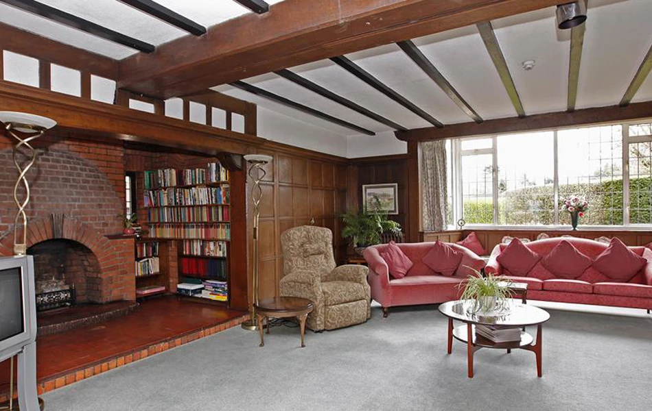 Bright and spacious lounge with sofas, beamed ceilings and large fireplace for residents at Abbeyfield, Austenmead