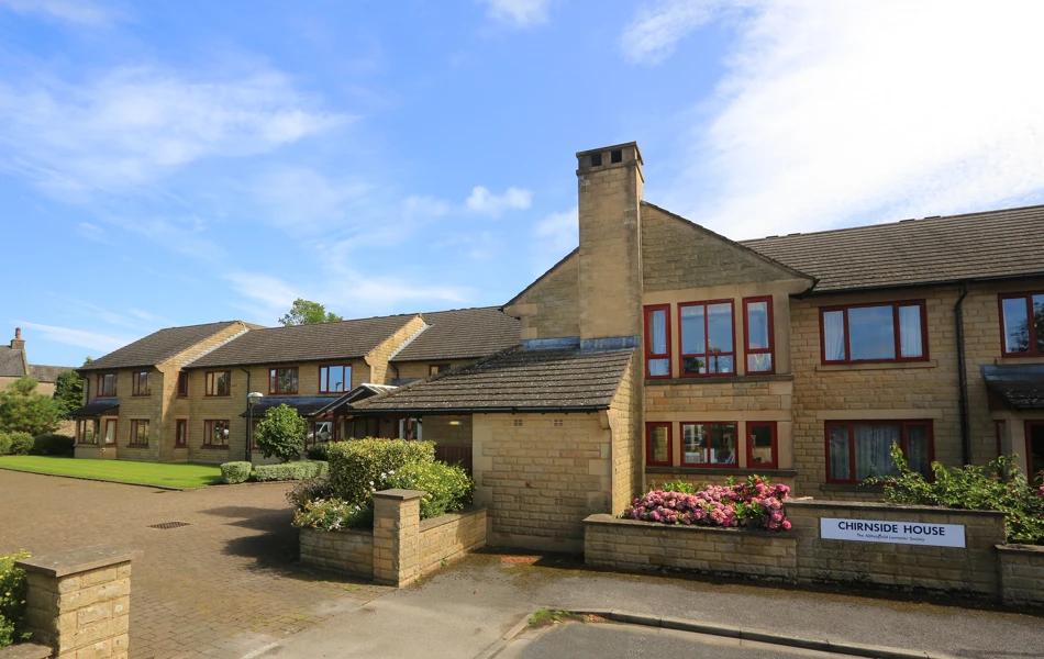 Chirnside house with short garden wall and bright flowers