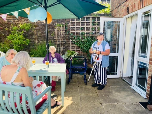 Residents sitting at garden furniture on the patio