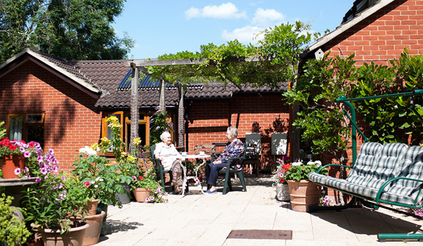 Residents enjoying the sun on the patio in the beautiful garden at Roundhay