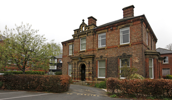 Large brick house with trees outside