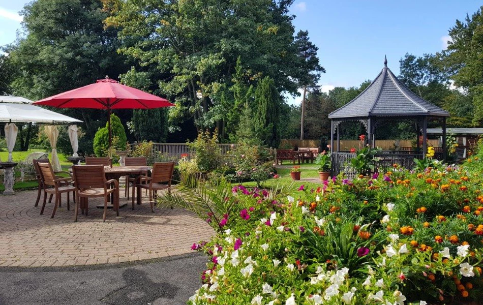 Garden, patio and pergola set amongst flowers at Bradbury House