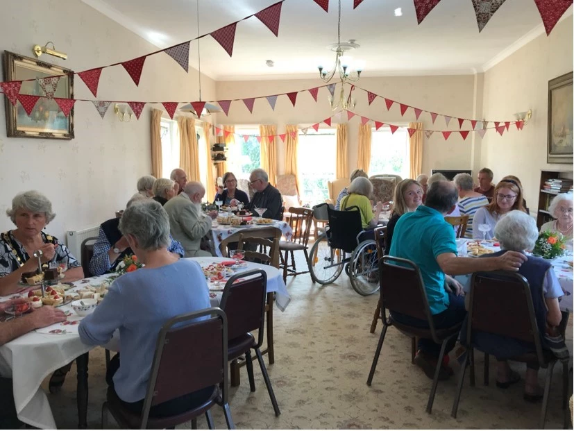 Residents Enjoying Afternoon Tea With Friends And Family In The Dining Room