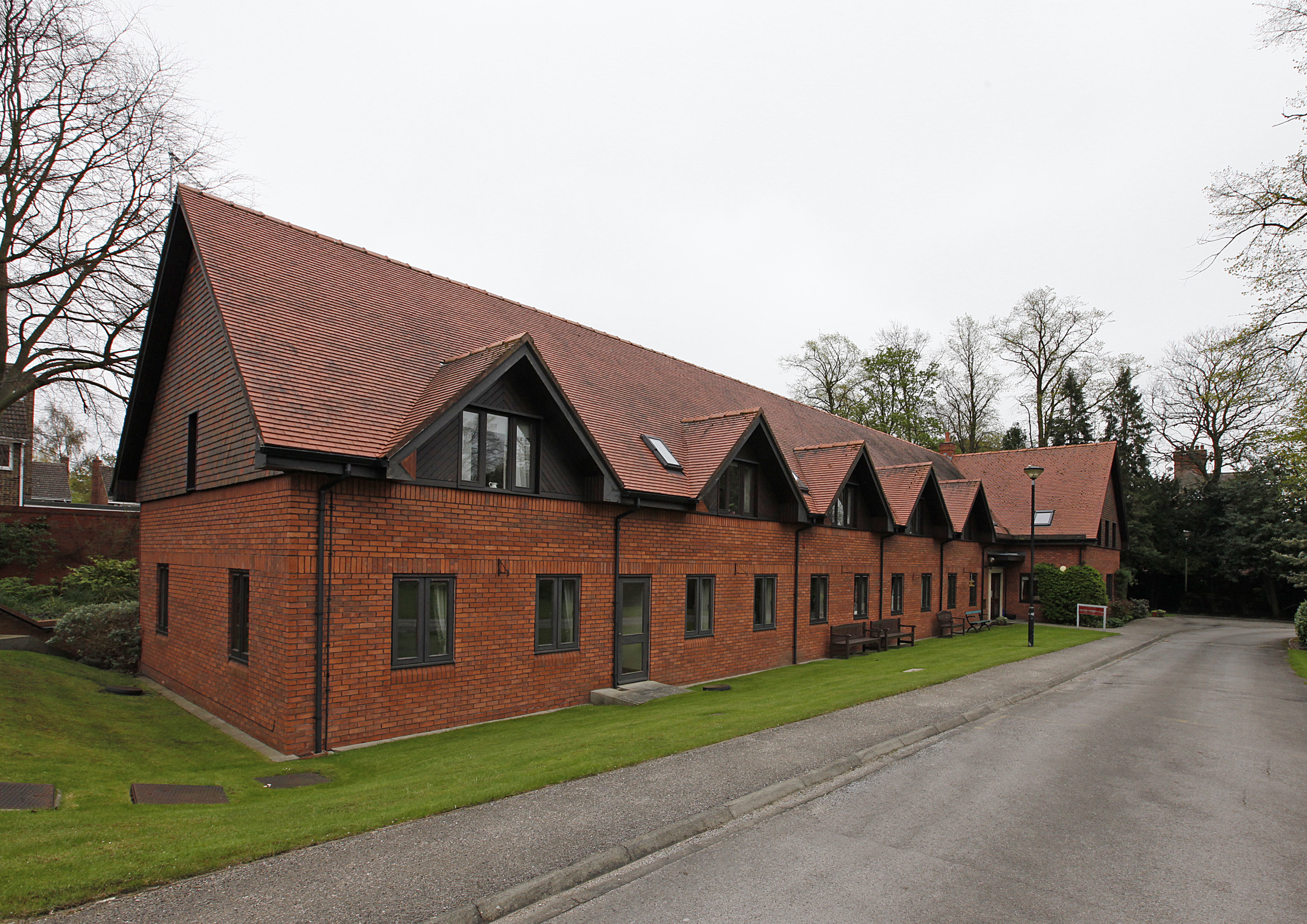A large red brick building with grass to the front and side