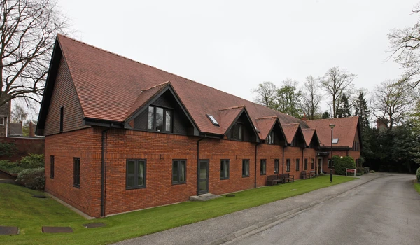 A large red brick building with grass to the front and side