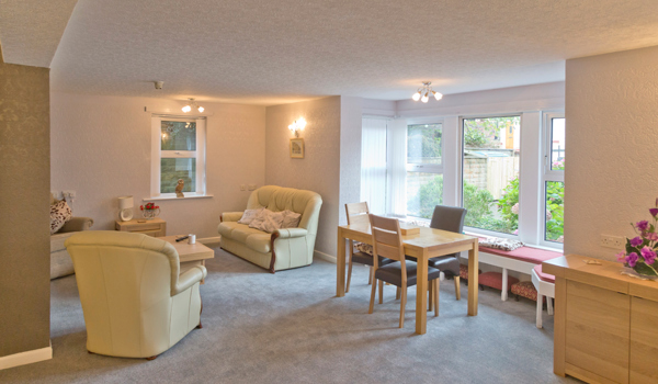 A bright cosy lounge area with seating areas for residents